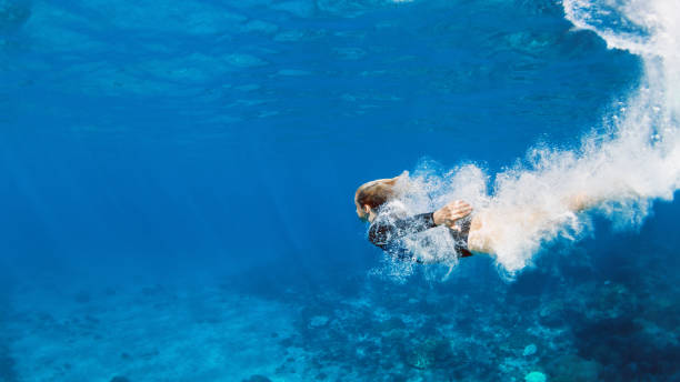 Young woman diving underwater stock photo