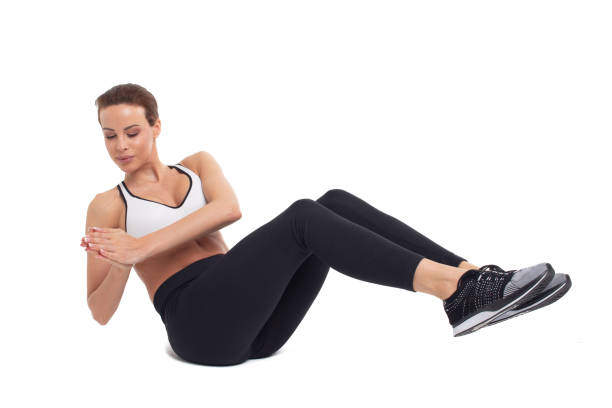 Young woman doing abs exercises, russian twist, isolated stock photo