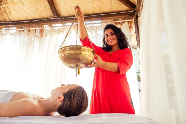 young woman doing healthcare indian traditional treatment in Ayurveda body constitution centre stock photo