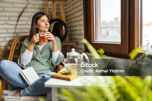 istock Young Woman drinking her winter tea and welcoming new day 1281961623