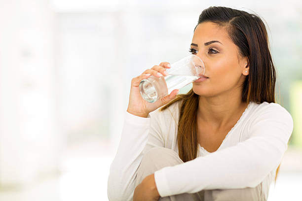 young woman drinking water stock photo