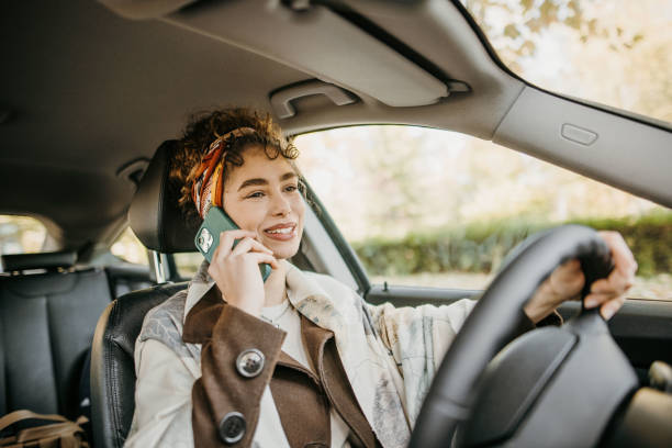 Young woman driving car and talking on phone stock photo