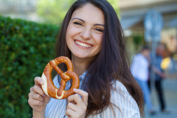 Young woman eating a pretzel stock photo