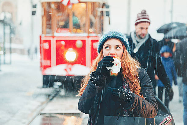 Young woman eating Turkish Wet Burger at Beyoglu, Istanbul Portrait of beautiful Young woman eat Turkish style wet hamburger (islak Burger) at Istiklal Street, Beyoglu, Istanbul in snowy winter day. hot middle eastern girls stock pictures, royalty-free photos & images