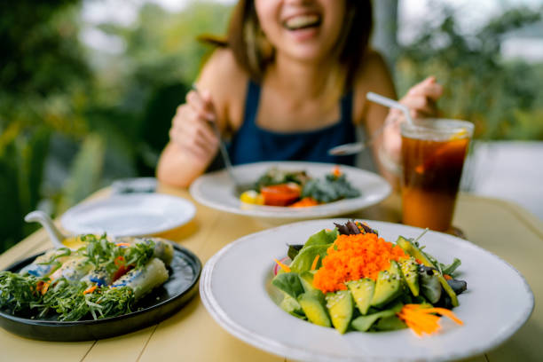 cô gái trẻ ăn thức ăn thuần chay tại nhà hàng - plant based meals hình ảnh sẵn có, bức ảnh & hình ảnh trả phí bản quyền một lần