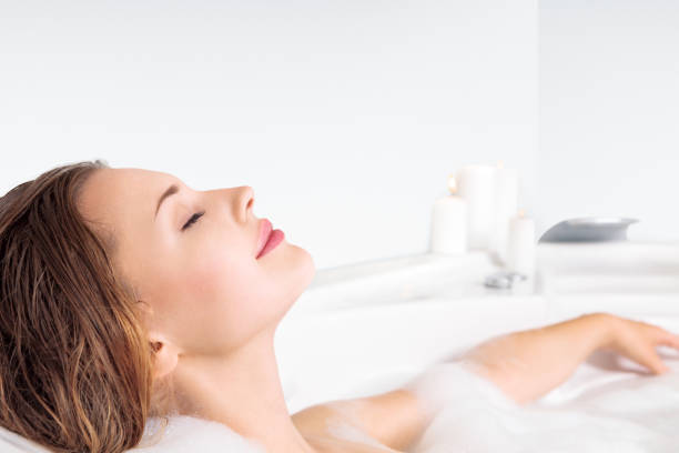 Young woman enjoying bathing in bathtub stock photo
