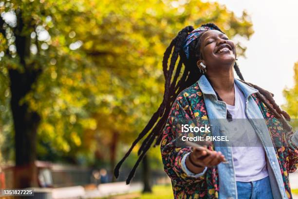 Young woman enjoying dancing and listening music outdoors