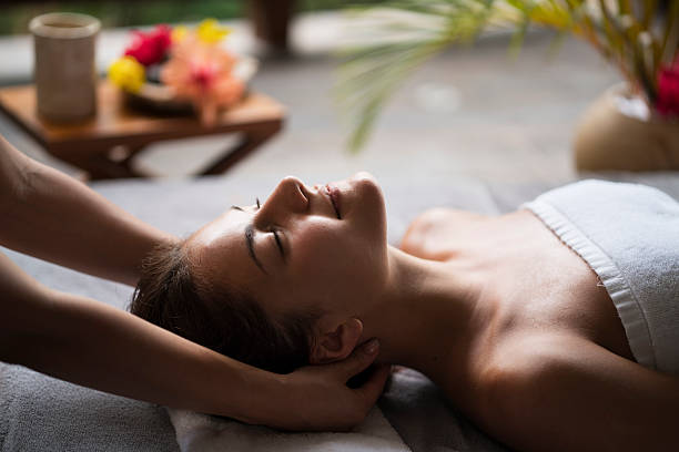 Young woman enjoying in a neck massage at the spa. stock photo