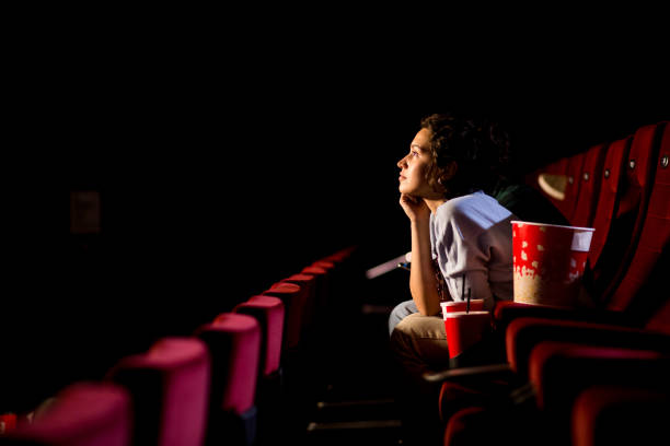 young woman enjoying watching movie at the cinema - movie imagens e fotografias de stock