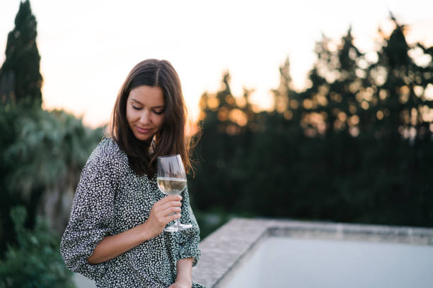 Young woman enjoys a glass of prosecco on rooftop terrace stock photo
