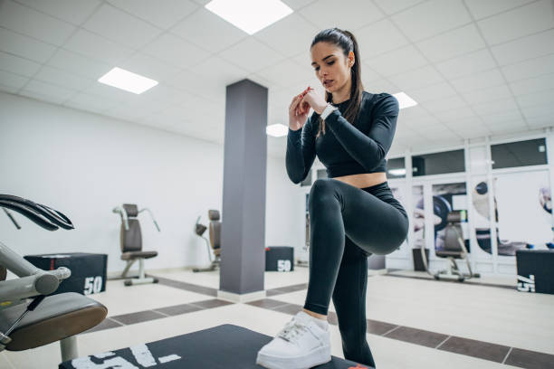 young woman exercising on step aerobics equipment - steps imagens e fotografias de stock