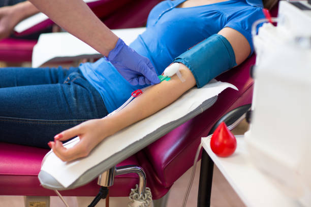 Young woman giving blood in a modern hospital Young woman giving blood in a modern hospital (color toned image) blood donation stock pictures, royalty-free photos & images
