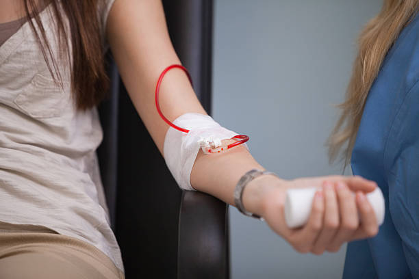 Young woman giving her blood stock photo
