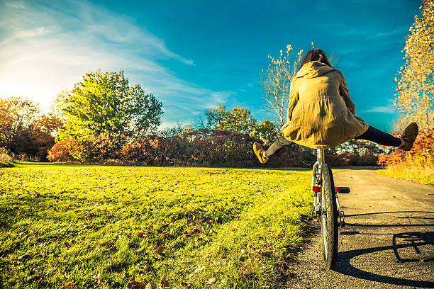 公園で自転車で楽しんでいる若い女性 - 秋　自電車 ストックフォトと画像