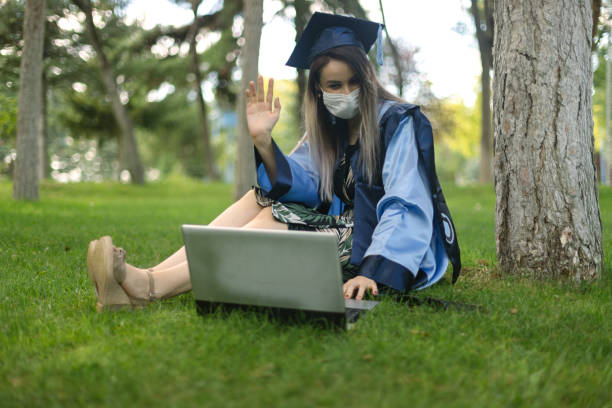 Young woman having video chats after her graduation ceremony Young woman having video chats after her graduation ceremony online computer science degree stock pictures, royalty-free photos & images