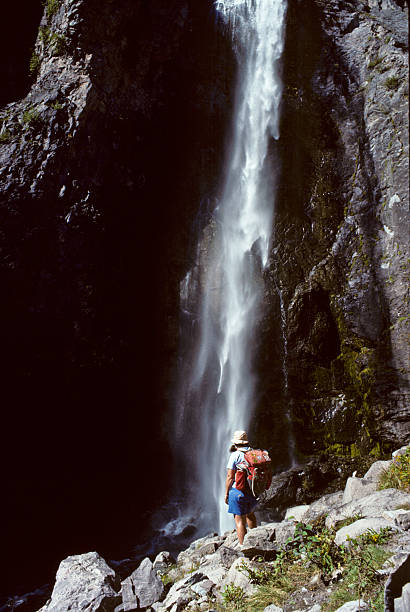Young Woman Hiker Enjoying a Waterfall Mount Rainier National Park, Washington, USA - July 24, 1988: A young woman hiker enjoys the view of lower Comet Falls. The falls are one of the largest in Mount Rainier National Park and a very popular destination. jeff goulden scanned film stock pictures, royalty-free photos & images