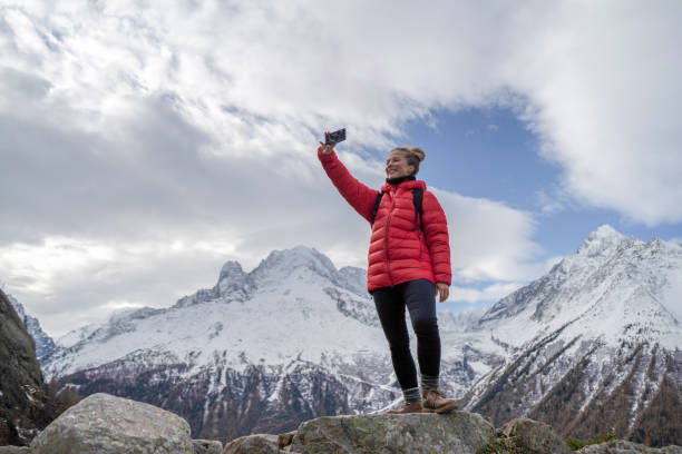 de jonge vrouwenwandelaar neemt selfie op bergpas - jas stockfoto's en -beelden