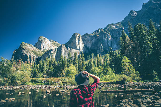 Young woman hiking in majestic landscape A shot of a young woman walking along a river in a majestic landscape. californian sierra nevada stock pictures, royalty-free photos & images