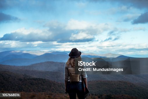 istock Young woman hiking through beautiful mountains. 1057668514