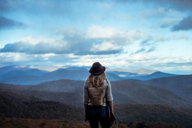 young woman hiking through beautiful mountains. - exploração imagens e fotografias de stock