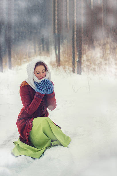 Young woman hold snow in mittens. Snowy forest Christmas background. stock photo