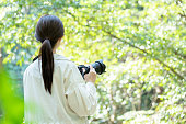 自然の中でカメラを持っている若い女性