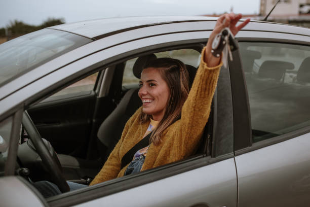 Young woman holding car keys inside a car stock photo
