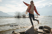 istock Young woman hops from rock to rock by the lakeshore 1308801805