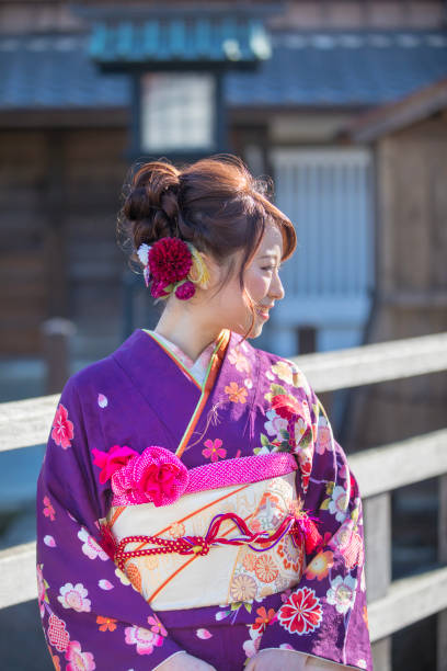Young woman in furisode kimono standing in traditional Japanese town Young woman in furisode kimono standing in traditional Japanese town furisode stock pictures, royalty-free photos & images