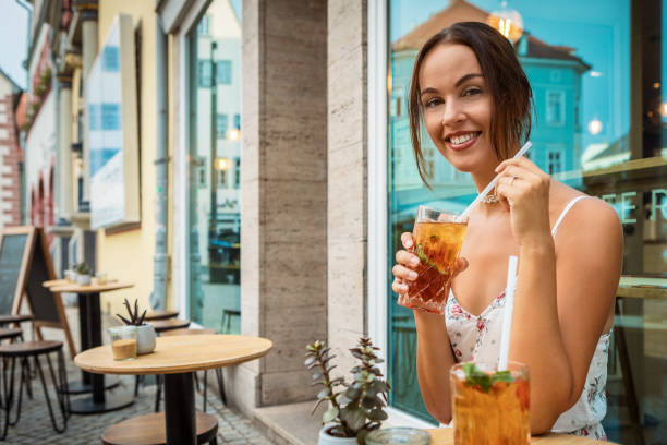 young woman in the city drinking ice tea stock photo