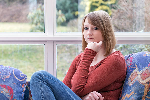Young woman is pensively looking at the camera. stock photo