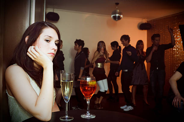 young woman is sitting alone in a nightclub stock photo