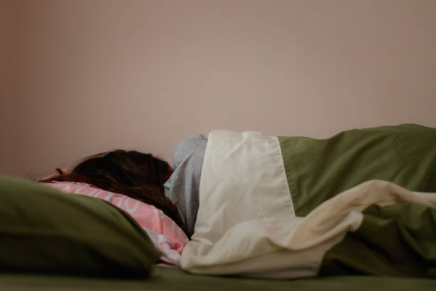 Young woman is sleeping from the back in bed Young woman is sleeping from the back in bed depression land feature stock pictures, royalty-free photos & images