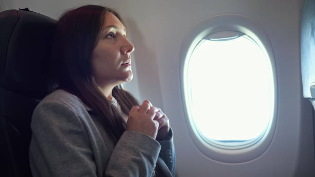Young woman is very afraid of flying on an airplane stock photo