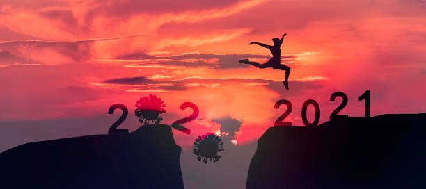 Young woman Jumping across the gap of the mountain from COVID-19 to 2021 New Year.  happy new year 2021 stock pictures, royalty-free photos & images