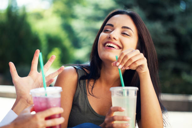 Young woman laughing and drinking soda stock photo