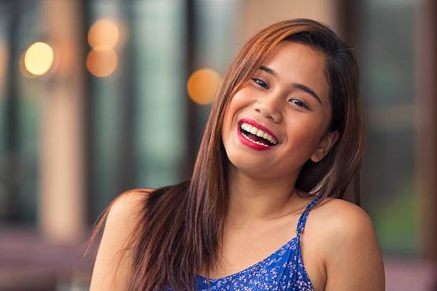 Young woman laughing Portrait of young woman laughing outdoors. filipino woman stock pictures, royalty-free photos & images