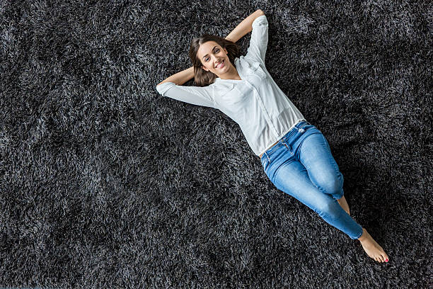 Young woman laying on the carpet stock photo
