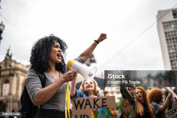 Young woman leading a demonstration using a megaphone