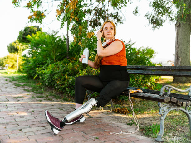 Young woman leg amputee exercising outdoors stock photo