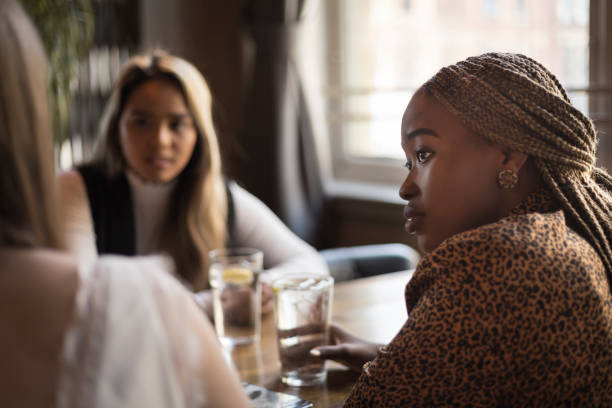 Young woman listening to her friends in a cafe bar stock photo