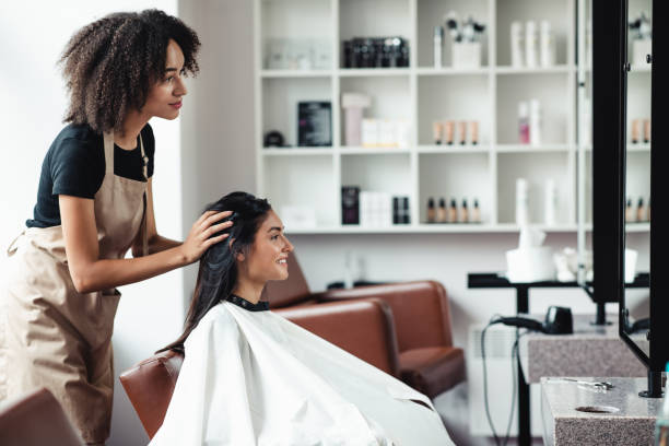 jonge vrouw die veranderingen zoekt, die nieuw kapsel bij schoonheidssalon proberen - lady barbers stockfoto's en -beelden