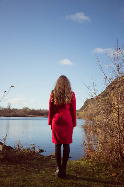 Young woman looking out over a lake stock photo