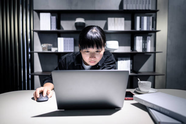 A young woman looks at her laptop intently in the office. stock photo