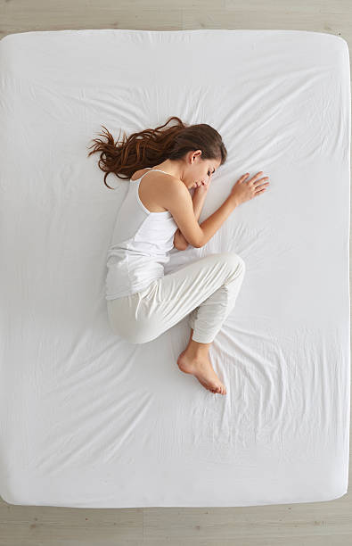 Young woman lying in bed stock photo
