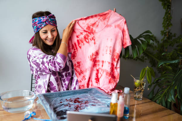 giovane donna fare tie dye in salotto - upcycling foto e immagini stock