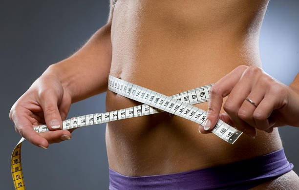 young woman measuring hips stock photo