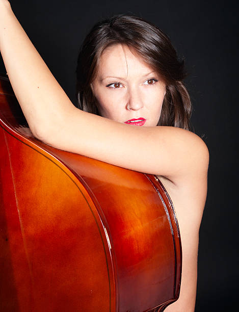 Young woman naked by double bass stock photo
