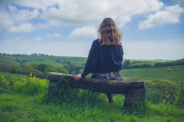 Young woman on bench in countryside stock photo