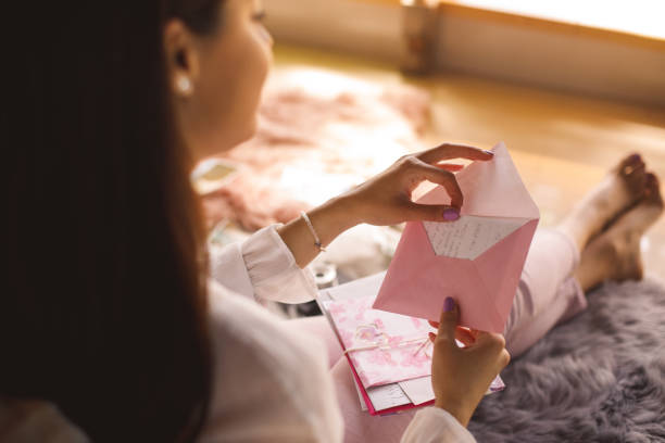 Young woman opening a love letter stock photo